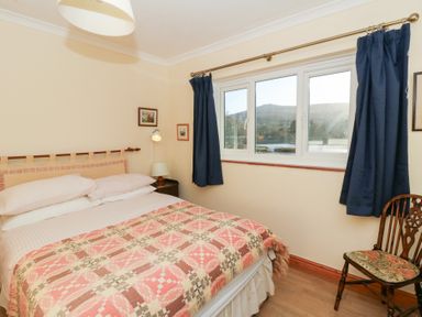 A bedroom with a bed and chair at Bryncyn in Newport, Pembrokeshire