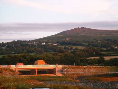 A bridge with hay bales and a mountain in the background at Bryncyn in Newport, Pembrokeshire