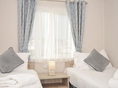 A bedroom with beds and a lamp at 2 Summerleaze Bude