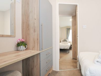 A bedroom with a dresser and a view of another room at 2 Summerleaze in Bude
