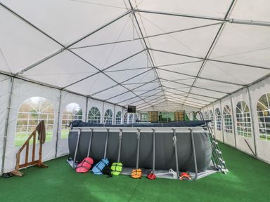A swimming pool and life jackets in a canopy tent at Pompian Lodge Bretherton near Tarleton
