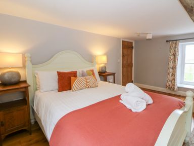A bedroom with a bed and bedside table at Secret Garden Cottage in Ciliau Aeron near Aberaeron