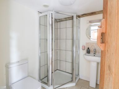 A bathroom with a shower, sink, and toilet at Secret Garden Cottage in Ciliau Aeron near Aberaeron