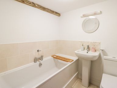 A bathroom with a bathtub, sink, and toilet at Secret Garden Cottage in Ciliau Aeron near Aberaeron