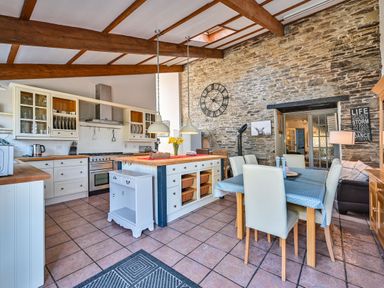 A kitchen with a table and chairs at The Old Farm House near Pelynt