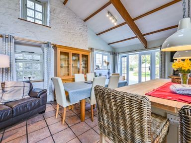 A dining room with a table and chairs at The Old Farm House near Pelynt