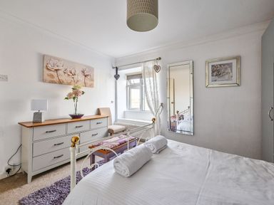 A bedroom with a bed and dresser at The Old Farm House near Pelynt
