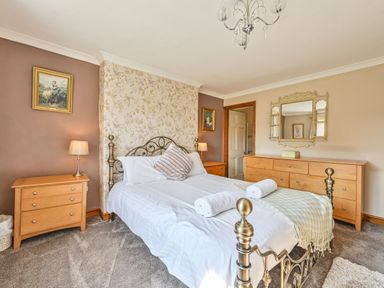 A bedroom with a bed and furniture at The Old Farm House near Pelynt