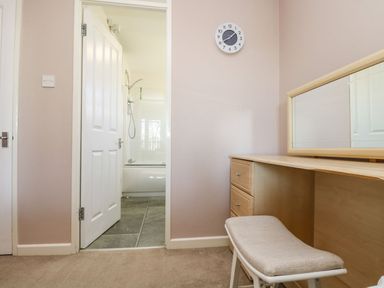 A bathroom with a bathtub visible through an open door at Valley Lodge 61 in Callington