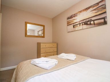 A bedroom with a bed and a dresser at Valley Lodge 61 in Callington