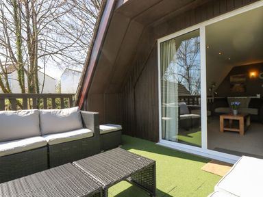 An outdoor seating area with a sofa and table at Valley Lodge 61 in Callington