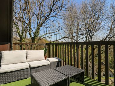 A balcony with seating and table at Valley Lodge 61 Callington