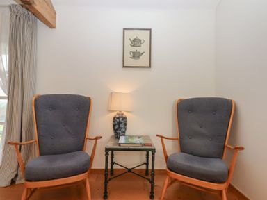 A sitting room with two rocking chairs and a lamp at Hilldown Granary near Bow