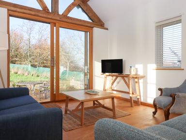 A living room with a sofa and table at Hilldown Cott near Bow