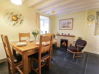 A dining room with a table and chairs at Noddfa in Penmachno