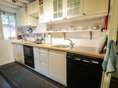 A kitchen with cabinets and appliances at Noddfa Penmachno