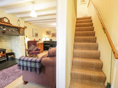A living room with a sofa and fireplace at Noddfa Penmachno