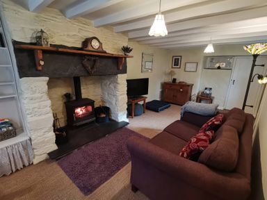 A living room with a fireplace and sofa at Noddfa in Penmachno