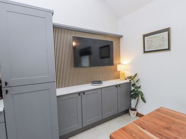 A living room with a television and a lamp at 2 Trem Y Mor Llanfwrog near Llanfachraeth