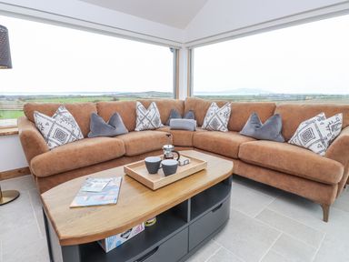 A snug with a sofa and coffee table at 2 Trem Y Mor Llanfwrog near Llanfachraeth