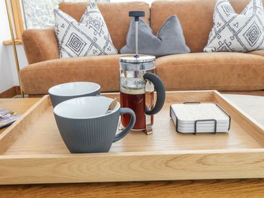 A living room with coffee cups and a French press on a tray at 2 Trem Y Mor in Llanfwrog near Llanfachraeth
