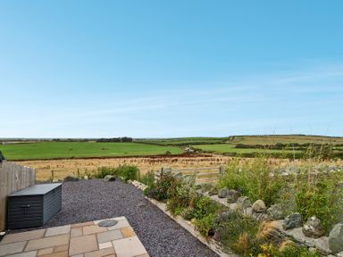 An outdoor view with a field and stone wall at 2 Trem Y Mor Llanfwrog near Llanfachraeth