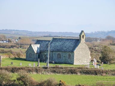 A church with gravestones in a field at Hen Penmynydd in Llanfwrog near Llanfachraeth