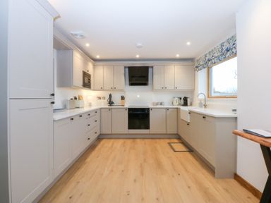 A kitchen with appliances and cabinets at Hen Penmynydd in Llanfwrog near Llanfachraeth
