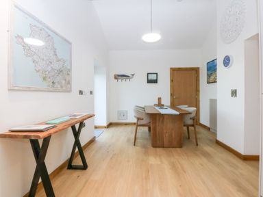A dining room with a table and chairs at Hen Penmynydd in Llanfwrog near Llanfachraeth