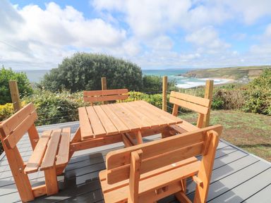 A wooden table with benches overlooking the sea at Shearwater in Praa Sands