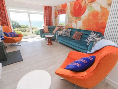 A living room with a sofa and armchairs at Shearwater, Praa Sands