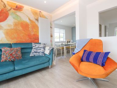 A living room with a sofa and an armchair at Shearwater in Praa Sands