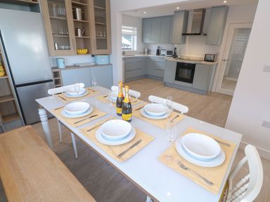 A kitchen with a dining table set for a meal at Shearwater in Praa Sands
