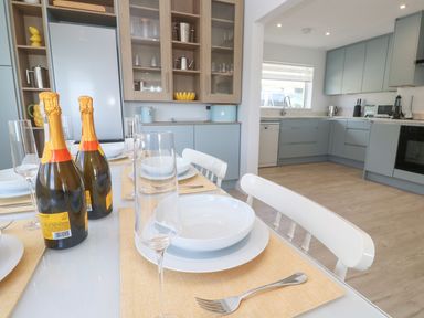 A dining room with champagne and plates at Shearwater in Praa Sands