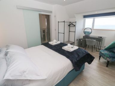 A bedroom with a bed and desk at Shearwater in Praa Sands