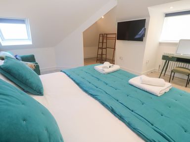 A bedroom with a bed, television and desk at Shearwater in Praa Sands