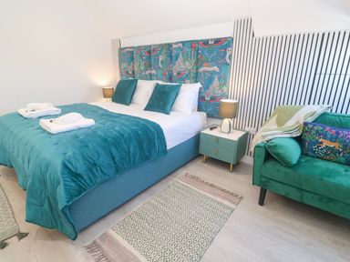 A bedroom with a bed and a couch at Shearwater in Praa Sands