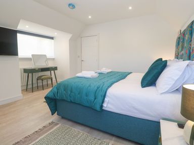 A bedroom with a bed and desk at Shearwater in Praa Sands
