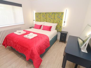 A bedroom with a bed and nightstand at Shearwater in Praa Sands