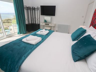 A bedroom with a bed and television at Shearwater in Praa Sands