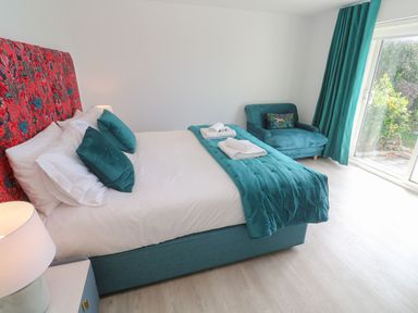 A bedroom with a bed and sofa at Shearwater in Praa Sands