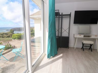 A bedroom with a desk and chair near a window at Shearwater in Praa Sands