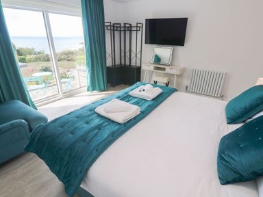 A bedroom with a bed and a television at Shearwater in Praa Sands