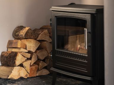 A stove with stacked wood logs at Green Bank in Betws-Y-Coed