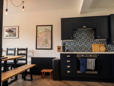 A kitchen with a table and chairs at Green Bank in Betws-Y-Coed