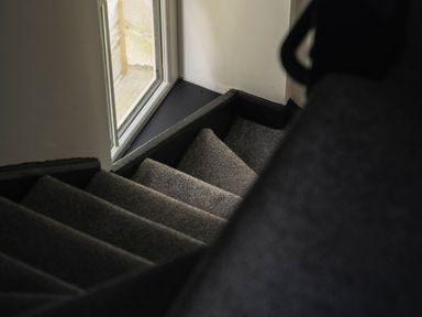 A staircase with a carpeted surface and a window at Green Bank in Betws-Y-Coed