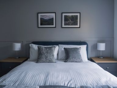A bedroom with a bed and framed pictures at Green Bank in Betws-Y-Coed