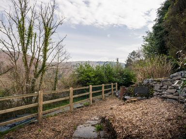 A garden with trees and a fence at Green Bank in Betws-Y-Coed
