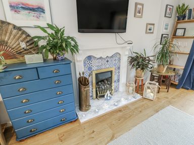 A living room with a television and fireplace at 16 Ffordd Meigan, Beaumaris