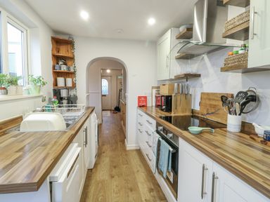A kitchen with cabinets and appliances at 16 Ffordd Meigan Beaumaris